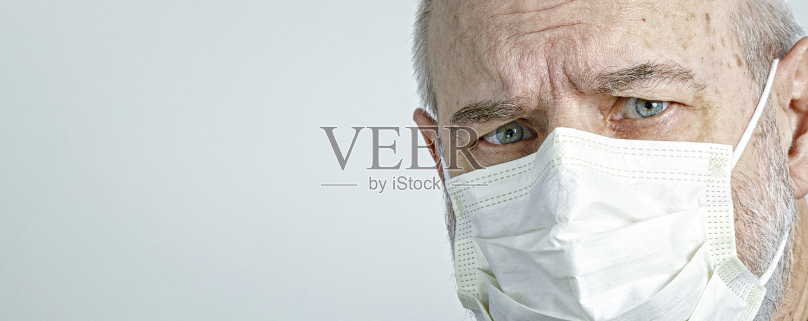 戴医用外科口罩的老年男人特写照片摄影图片