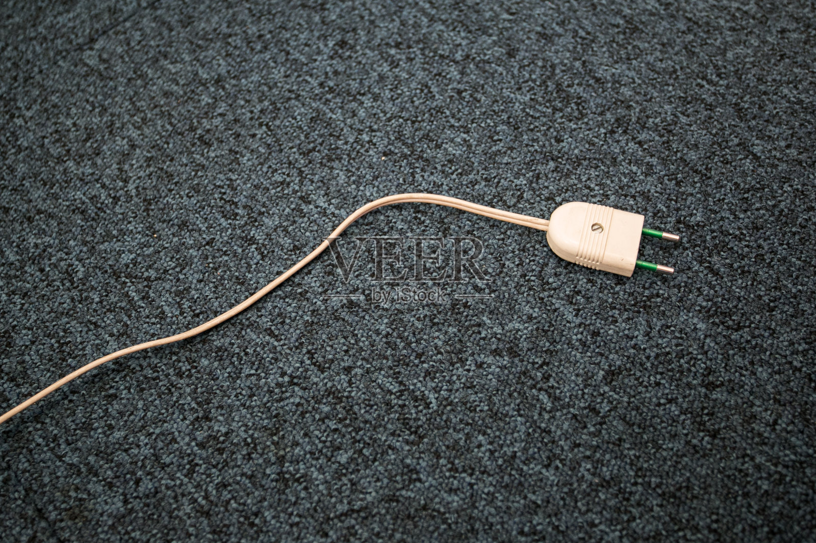 地毯地板上未插电灯电缆。旧灯电缆照片摄影图片