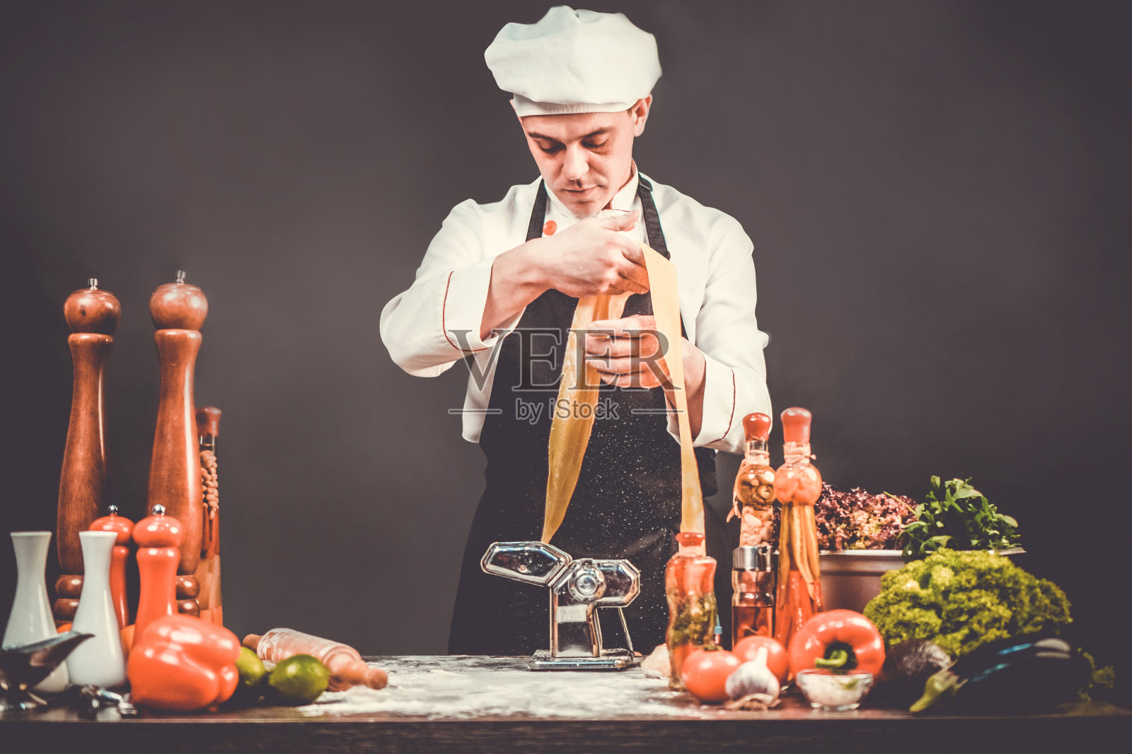 手工制作意大利面过程。意大利厨师在厨房餐桌上烹饪手工面食。照片摄影图片