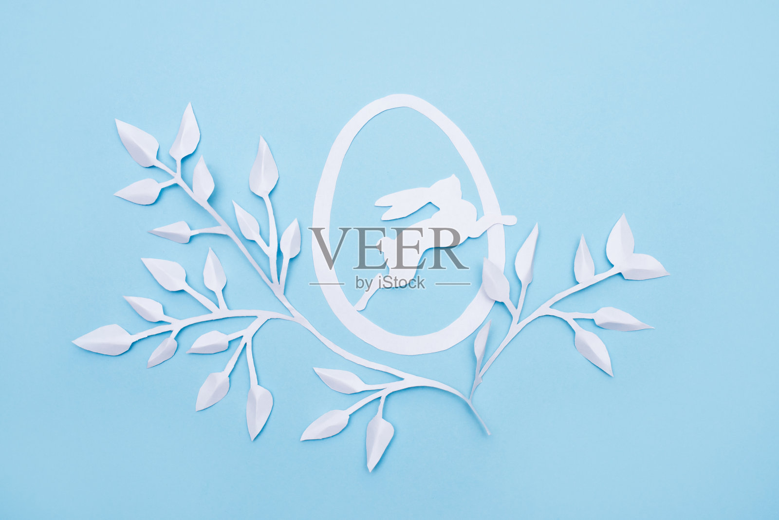 复活节快乐主题：蓝色背景上的白色兔子和纸叶照片摄影图片