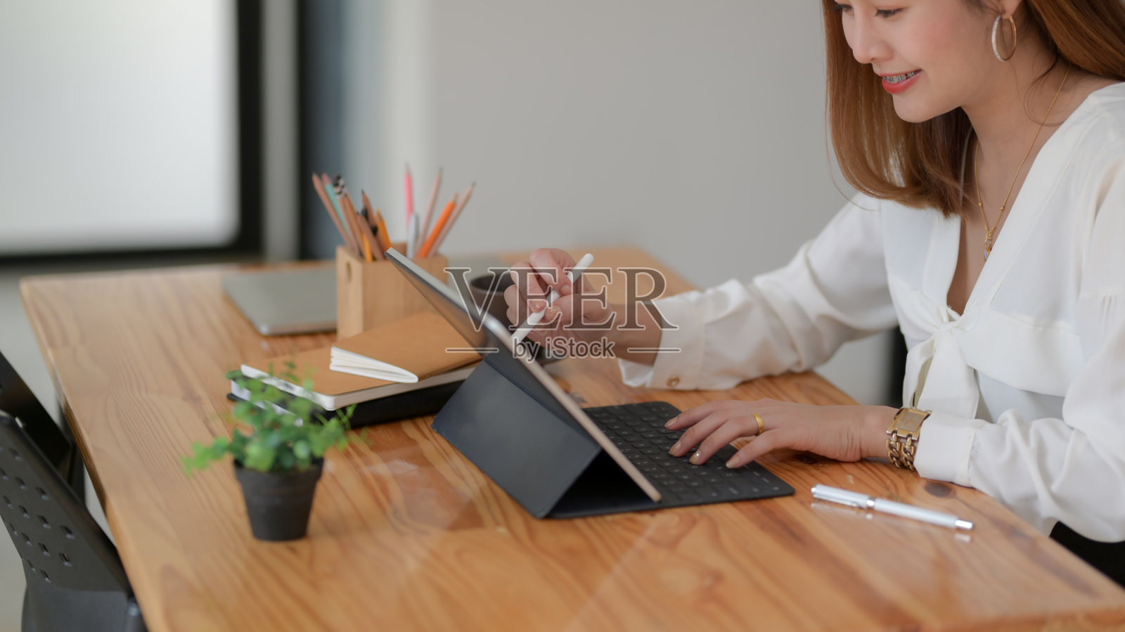 侧视图的自由职业者绘图在数字平板与文具在木制书桌上照片摄影图片