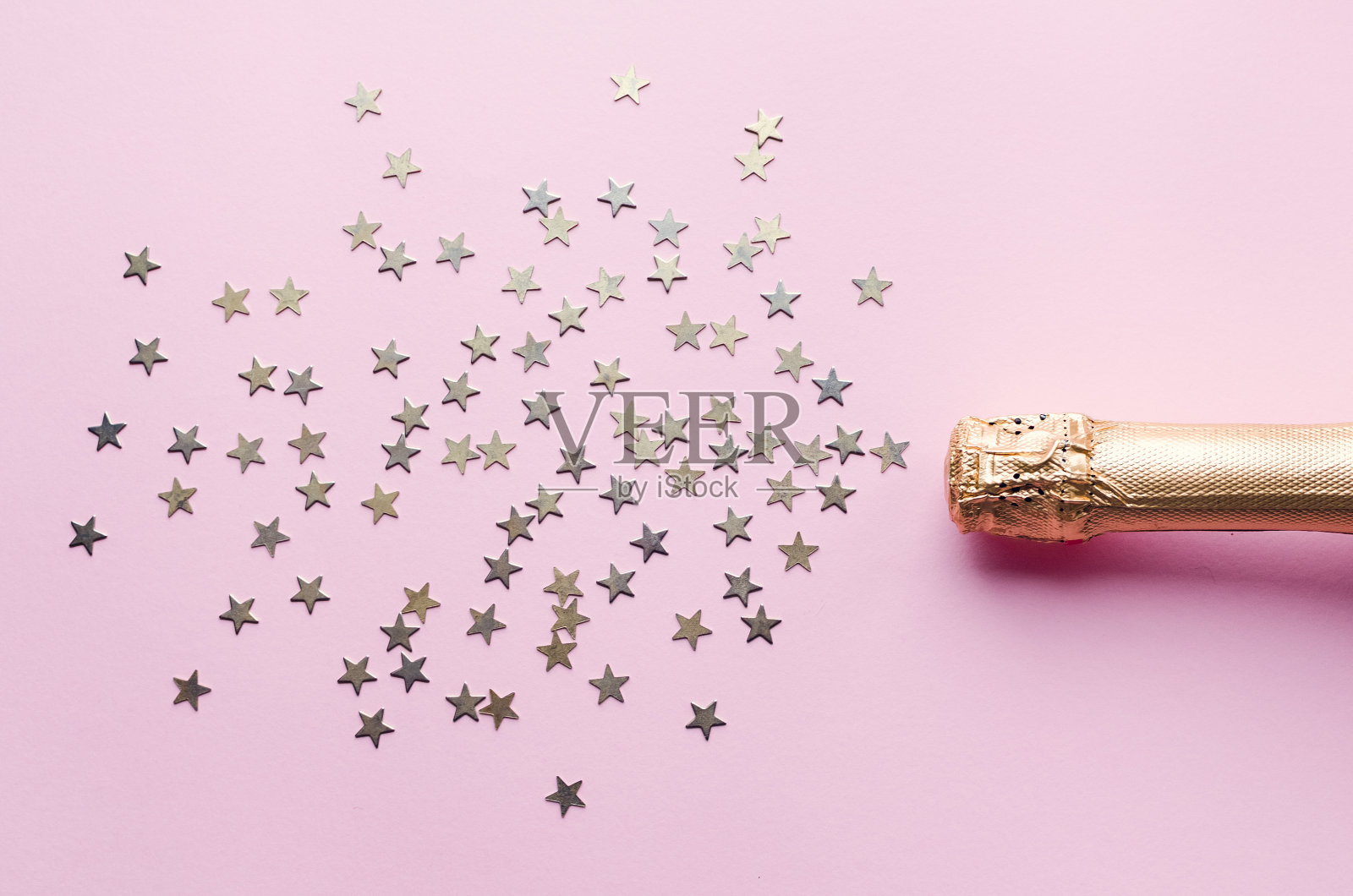 粉色背景上的香槟酒瓶照片摄影图片