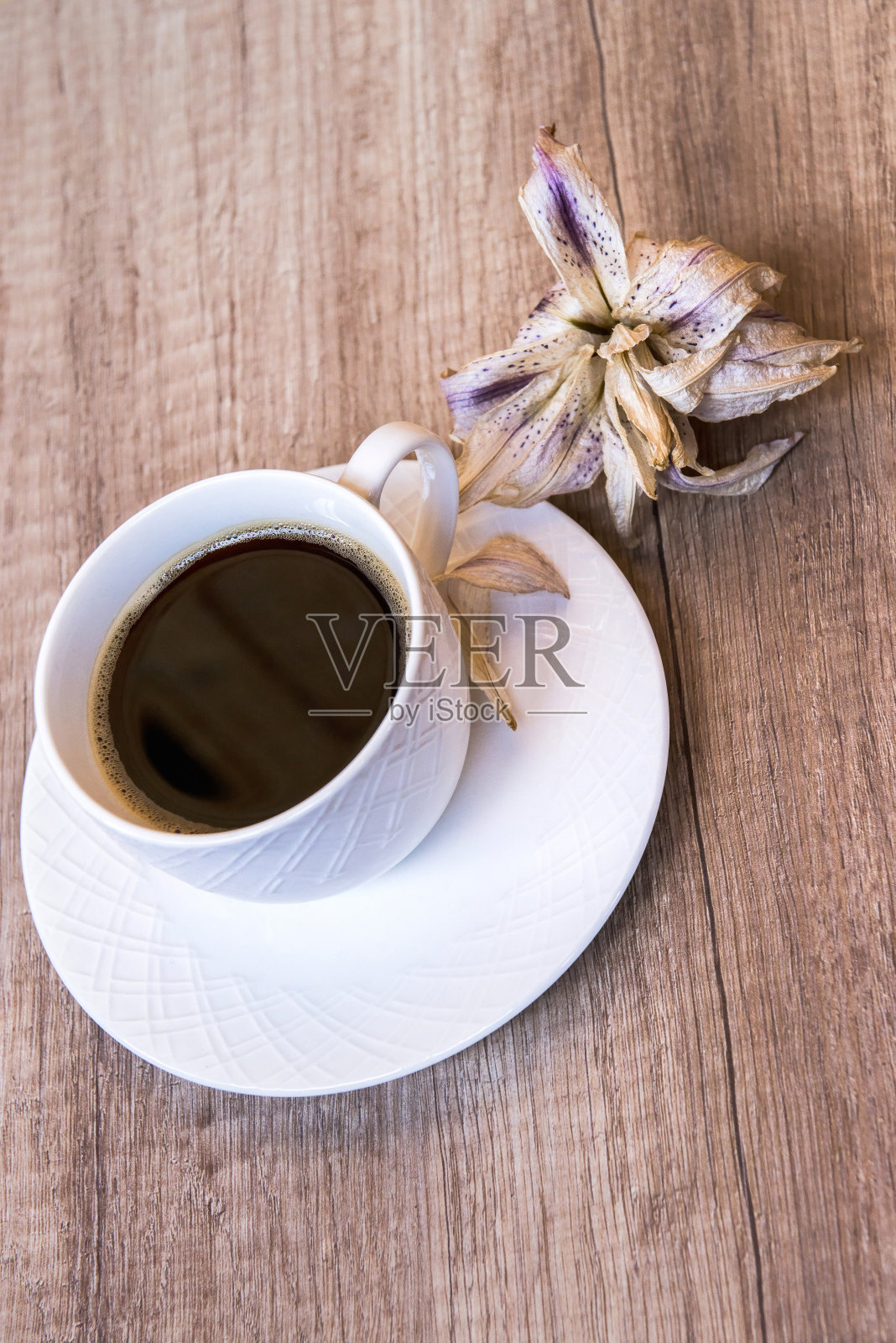 早上好，黑咖啡放在一张木桌上，旁边是一株干兰花照片摄影图片