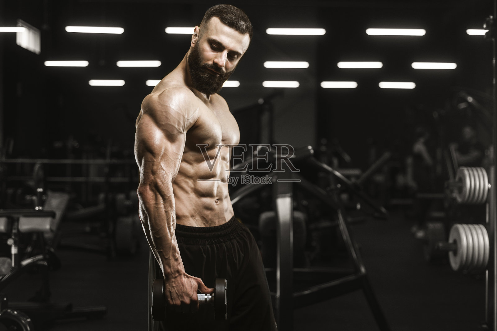 健壮的男人进行杠铃弯举锻炼，打造健美身材照片摄影图片