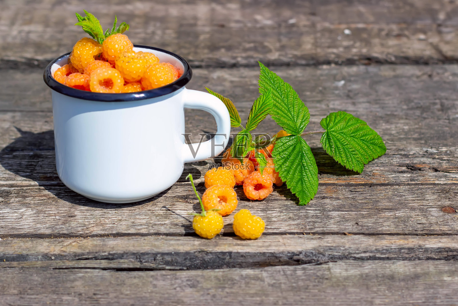 夏天，成熟的甜覆盆子放在木桌上。照片摄影图片