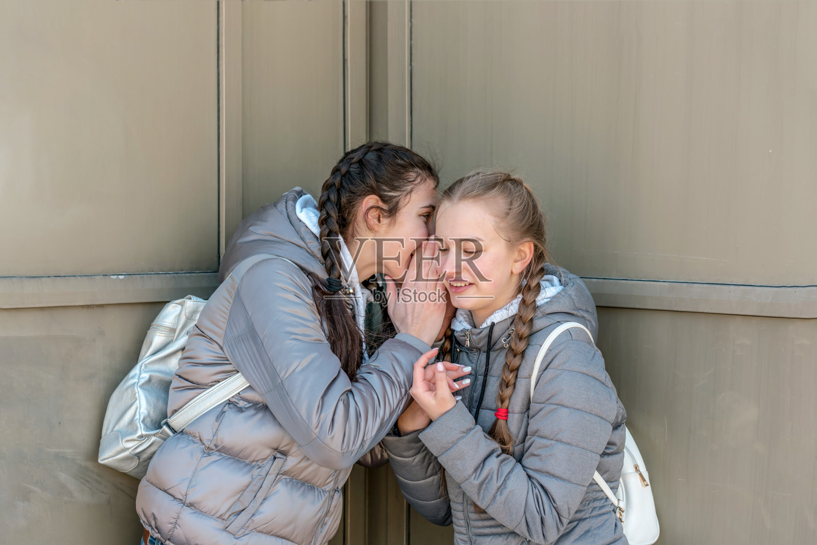 年轻姑娘们站在墙头窃窃私语照片摄影图片