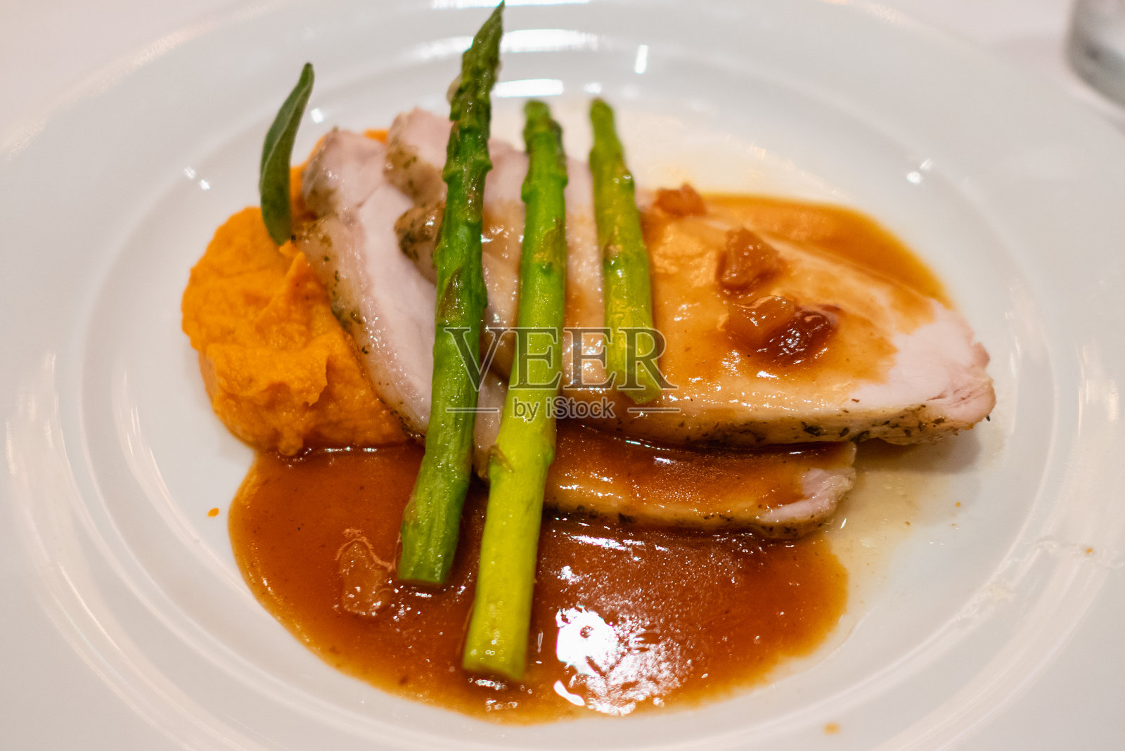 烤猪肉配芦笋、土豆泥和沙司照片摄影图片