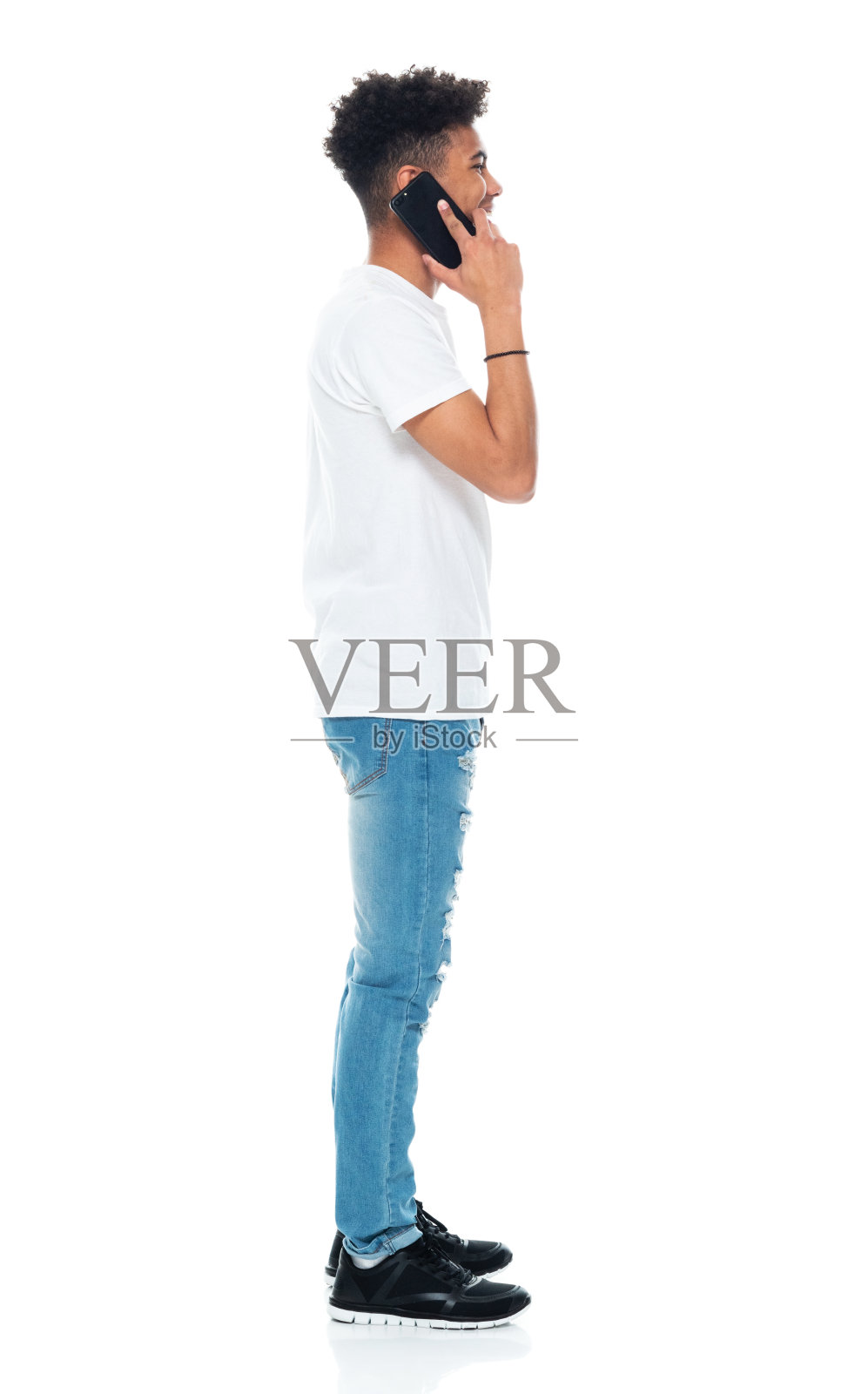 Z世代青少年男孩穿着衬衫，使用手机站在白色背景前照片摄影图片