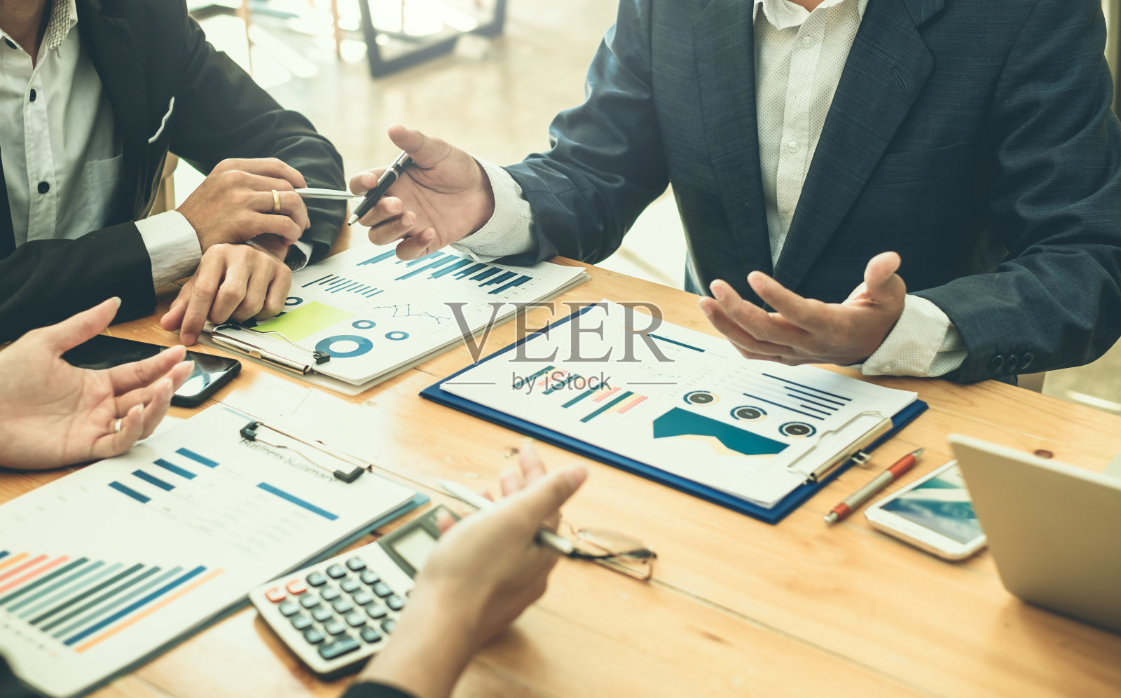 商务人士聚在一起讨论投资和图表财务信息。照片摄影图片