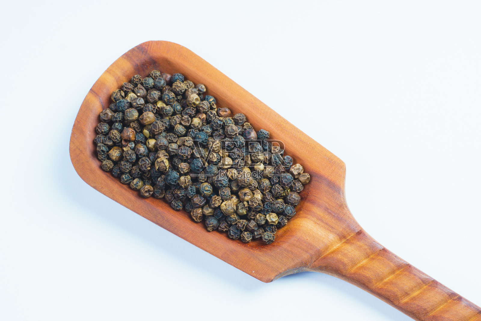 白色背景上放着胡椒籽的木制抹刀照片摄影图片