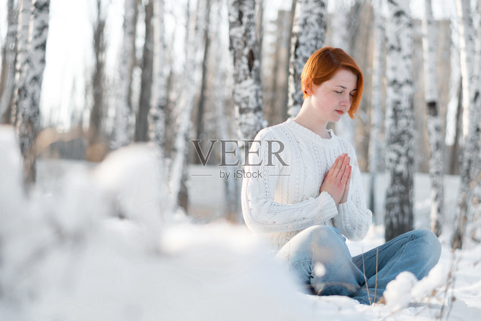 年轻美丽的女人在森林里祈祷。照片摄影图片