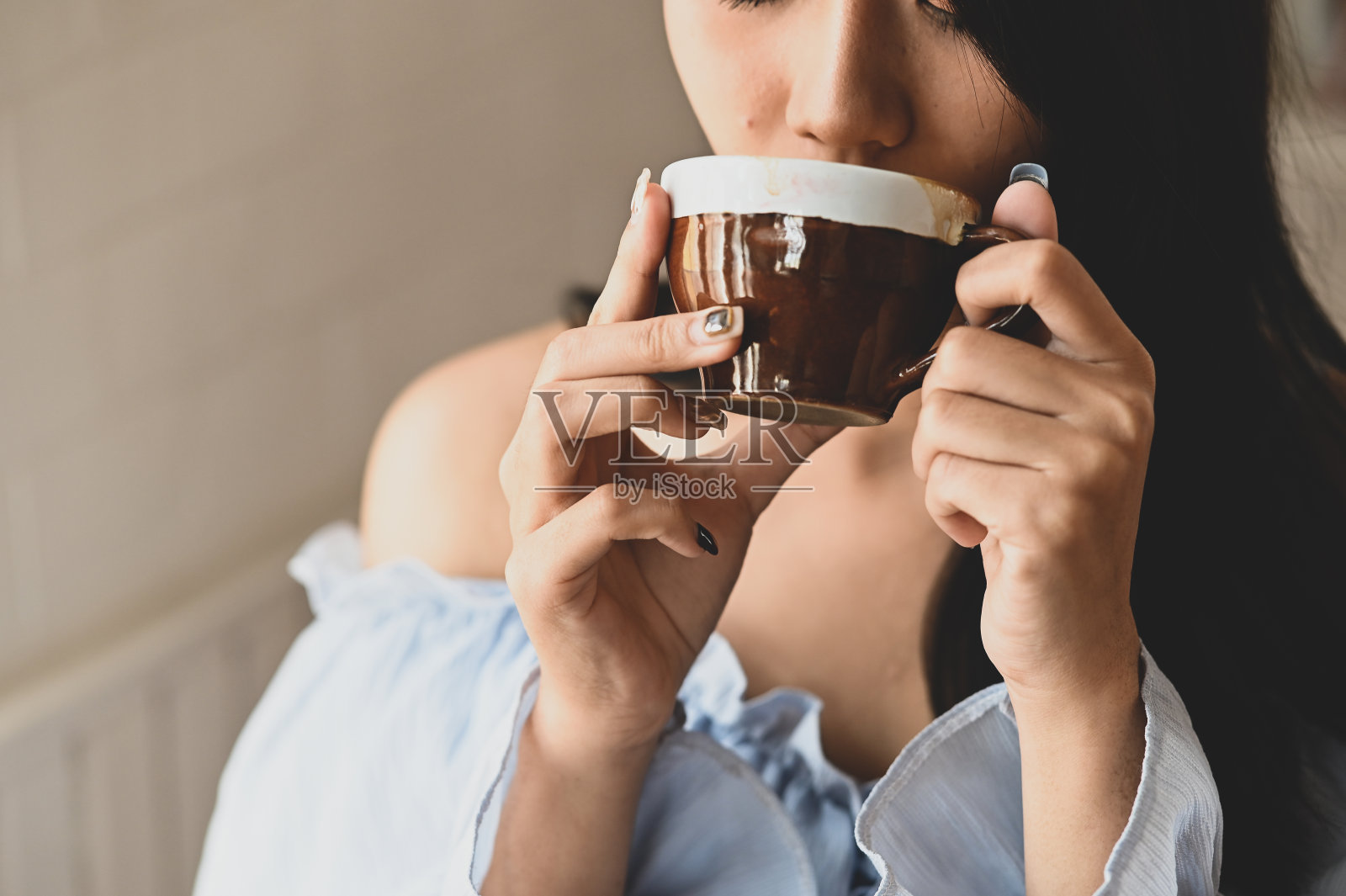 年轻漂亮的女孩在客厅里手捧咖啡杯的照片，放松时光概念照片摄影图片