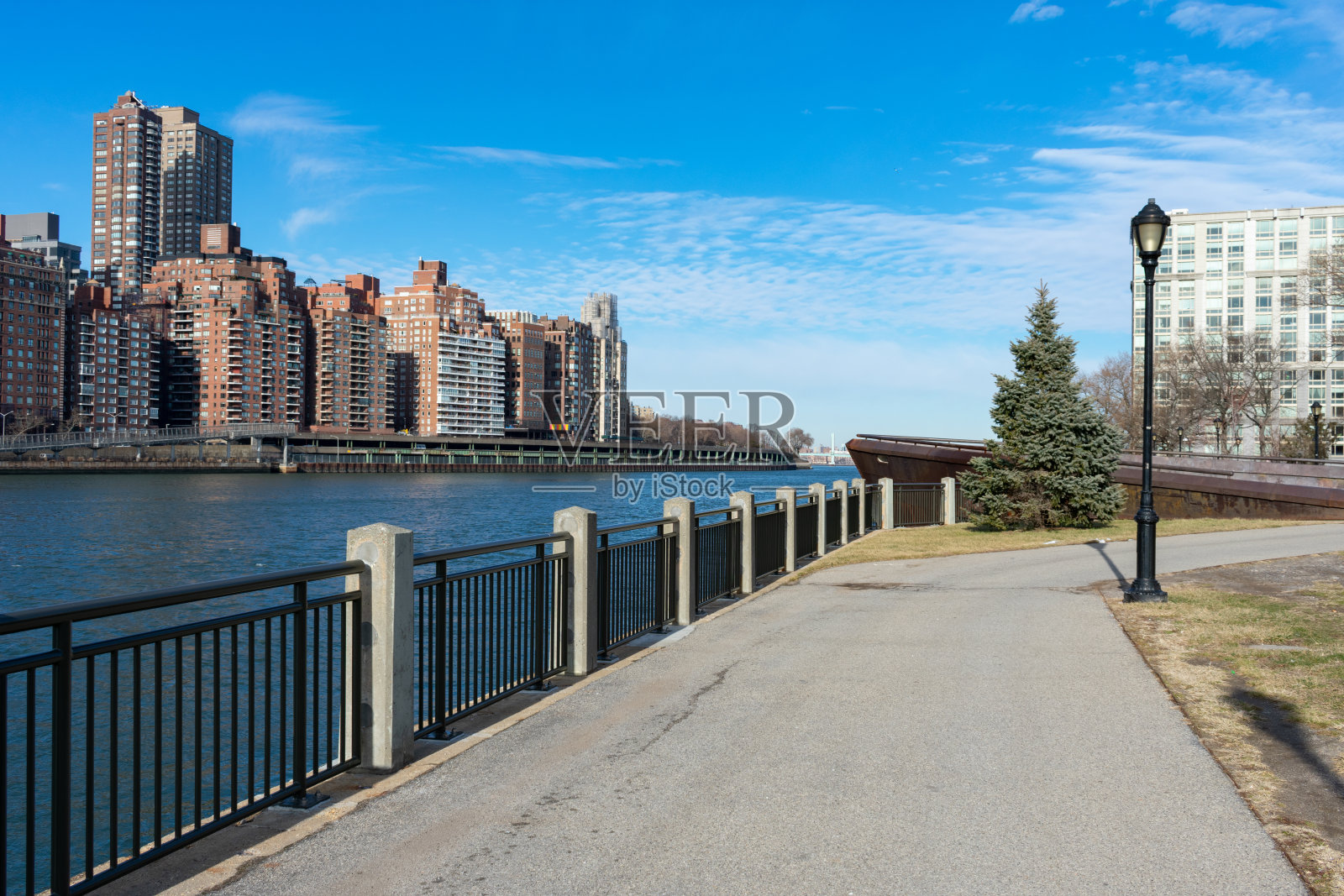沿着罗斯福岛东河的滨水区，望向纽约市上东区的天际线照片摄影图片