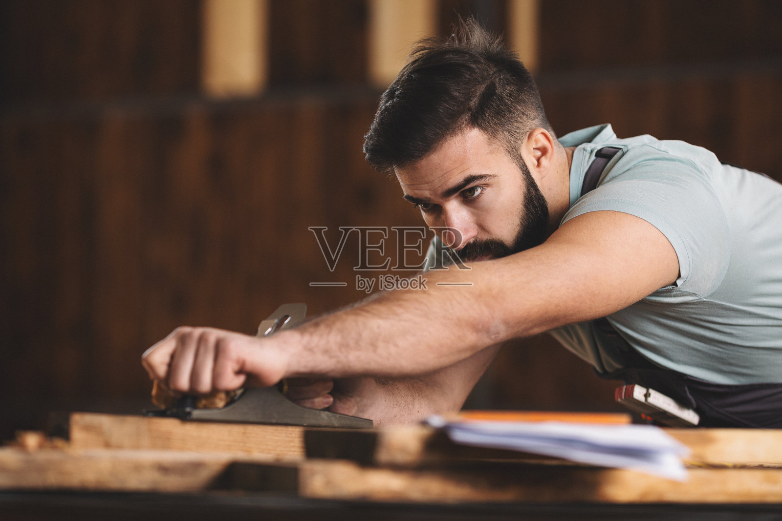 年轻的木匠在他的车间工作照片摄影图片