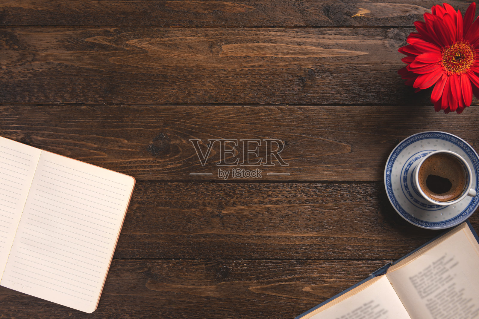 舒适的工作场所。打开笔记本和书，咖啡杯，花，在木制的背景。平铺，俯视图，拷贝空间。照片摄影图片