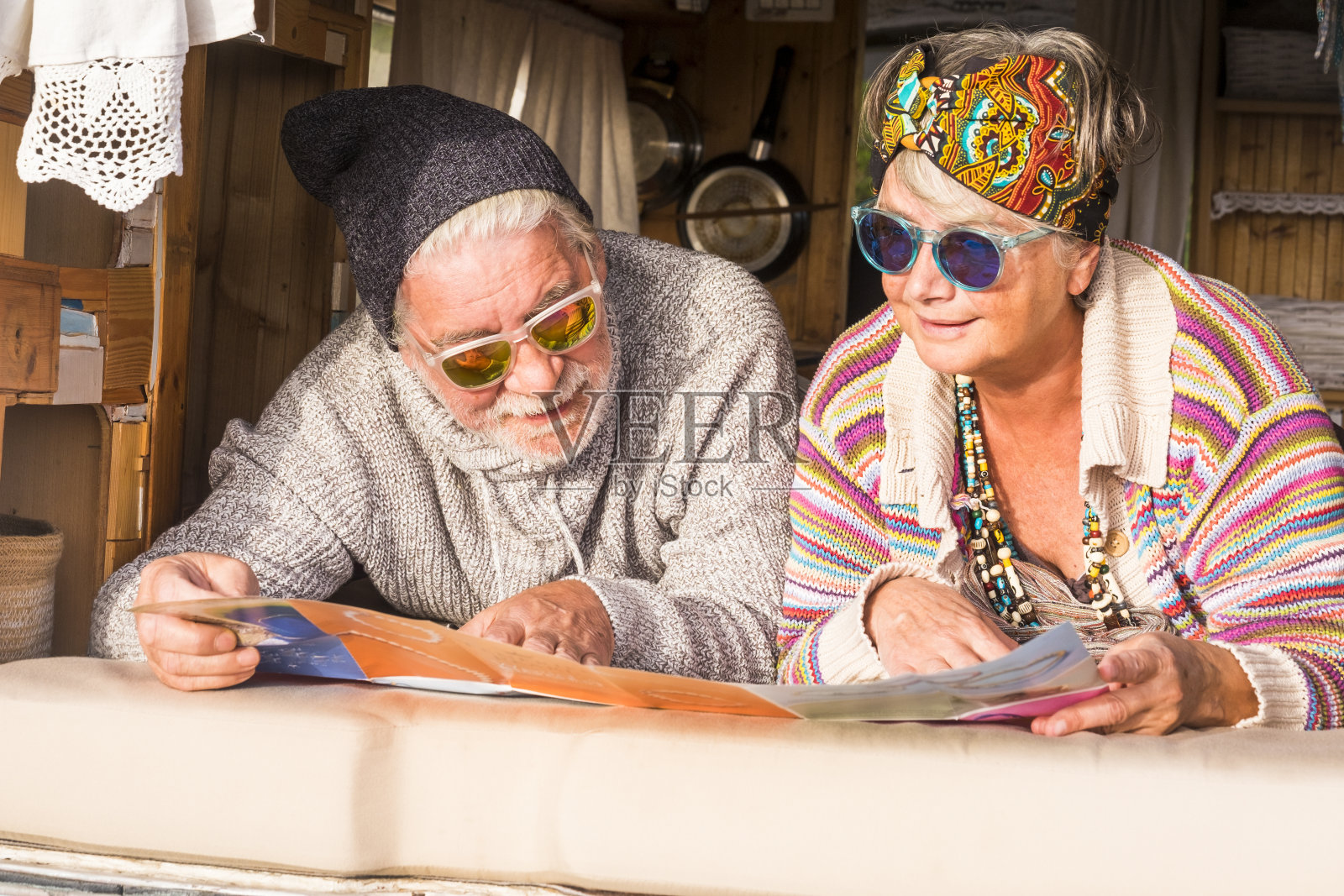 一对幸福的退休白人老年人享受旅行和旅游的生活方式，看地图和计划的旅行躺在一个古老的手工定制货车照片摄影图片