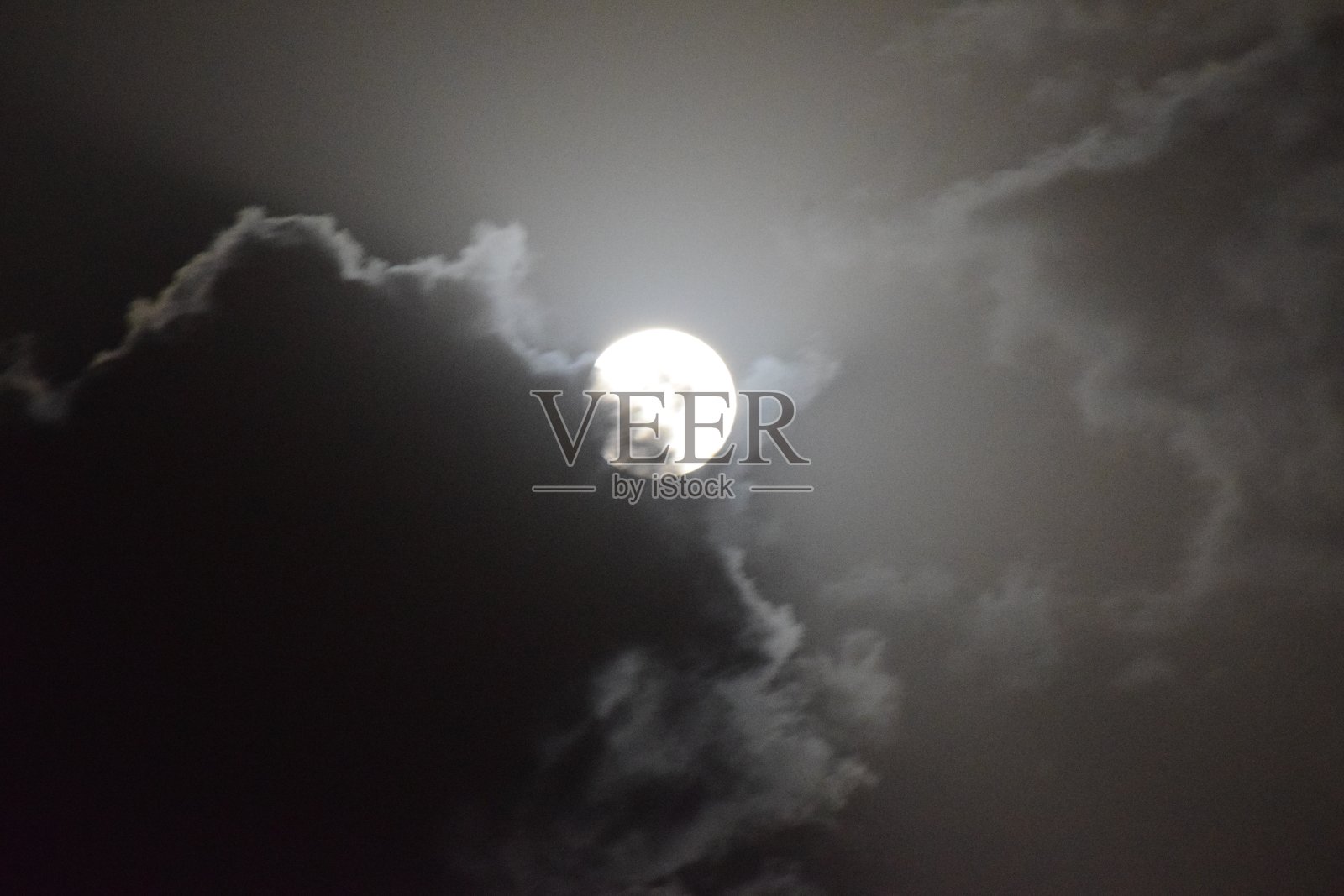 在天空中多云的夜晚，满月的景象照片摄影图片
