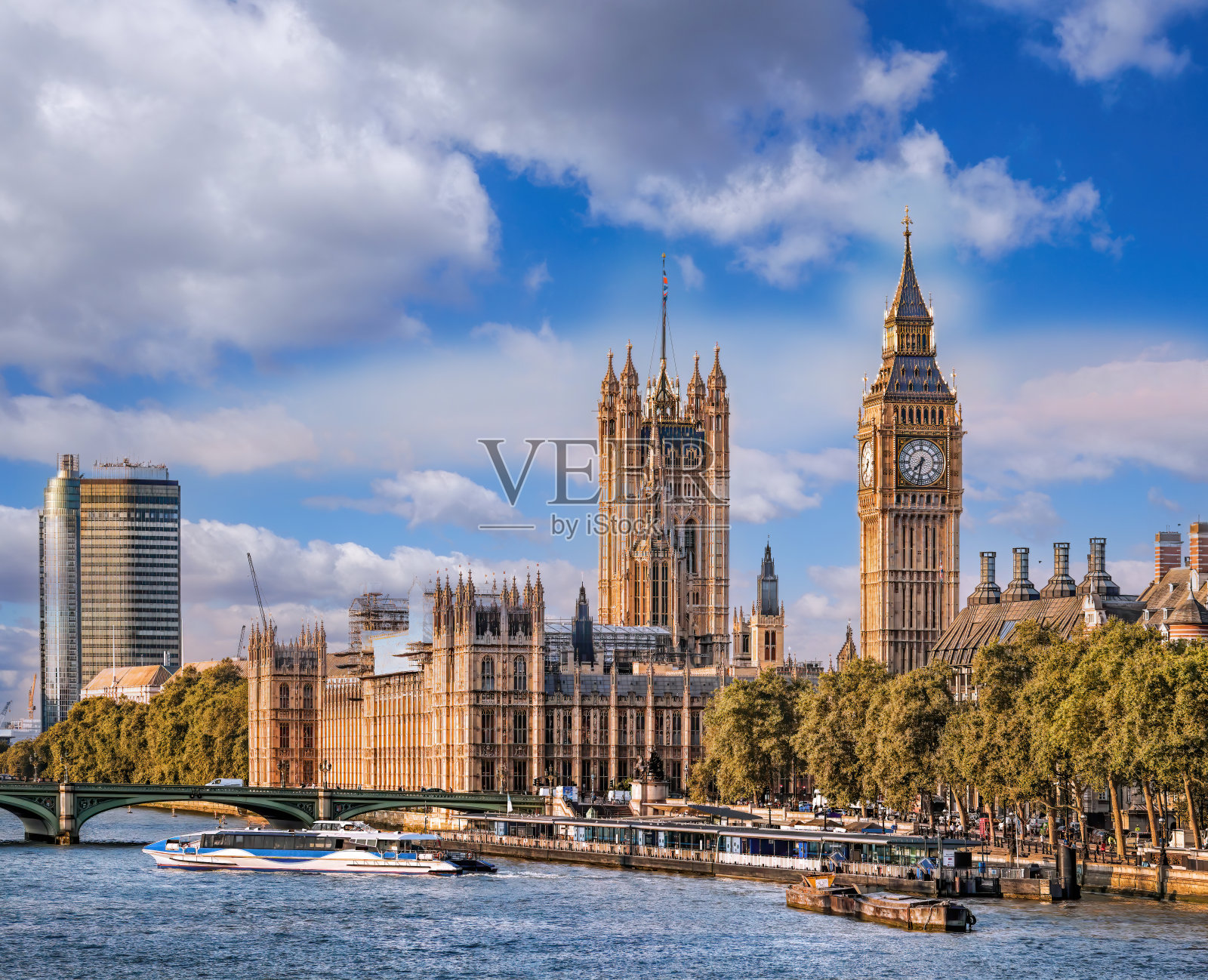 英国伦敦，河上船只与大本钟和议会大厦照片摄影图片