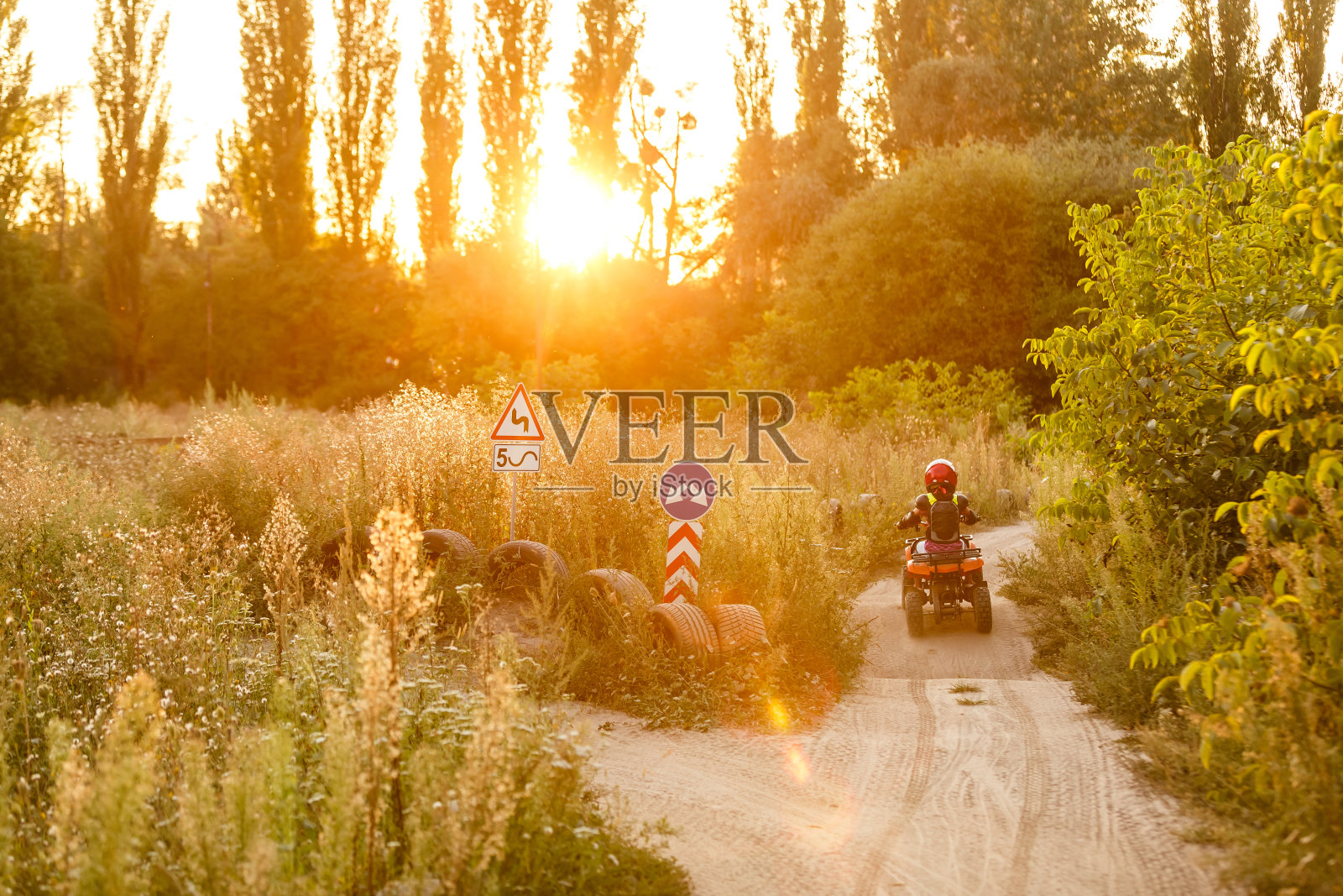 白天在路上玩耍的快乐小女孩，在公园里骑着四轮摩托车，在自然中玩耍，幸福的概念照片摄影图片
