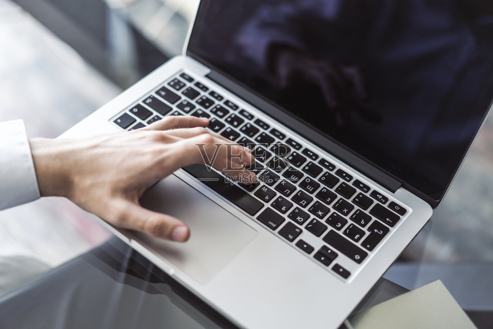 商人键入笔记本电脑键盘在阳光明媚的办公室，商业和技术的概念。近距离照片摄影图片