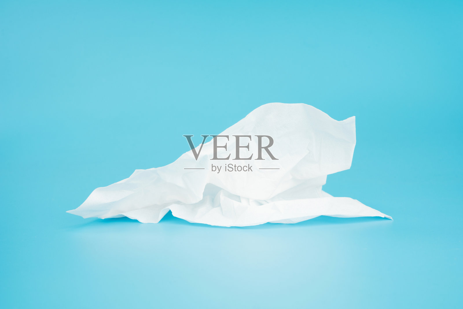 蓝色背景上揉皱的纸巾照片摄影图片