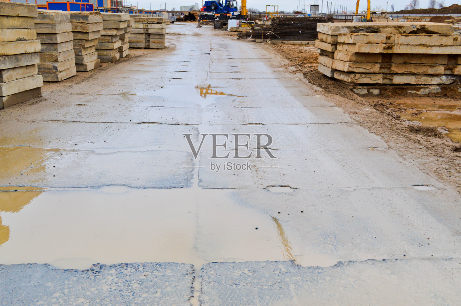 在建筑物和房屋的施工现场，劣质的混凝土弄脏了带有接缝和裂缝的块和板的道路。后面的背景。纹理照片摄影图片