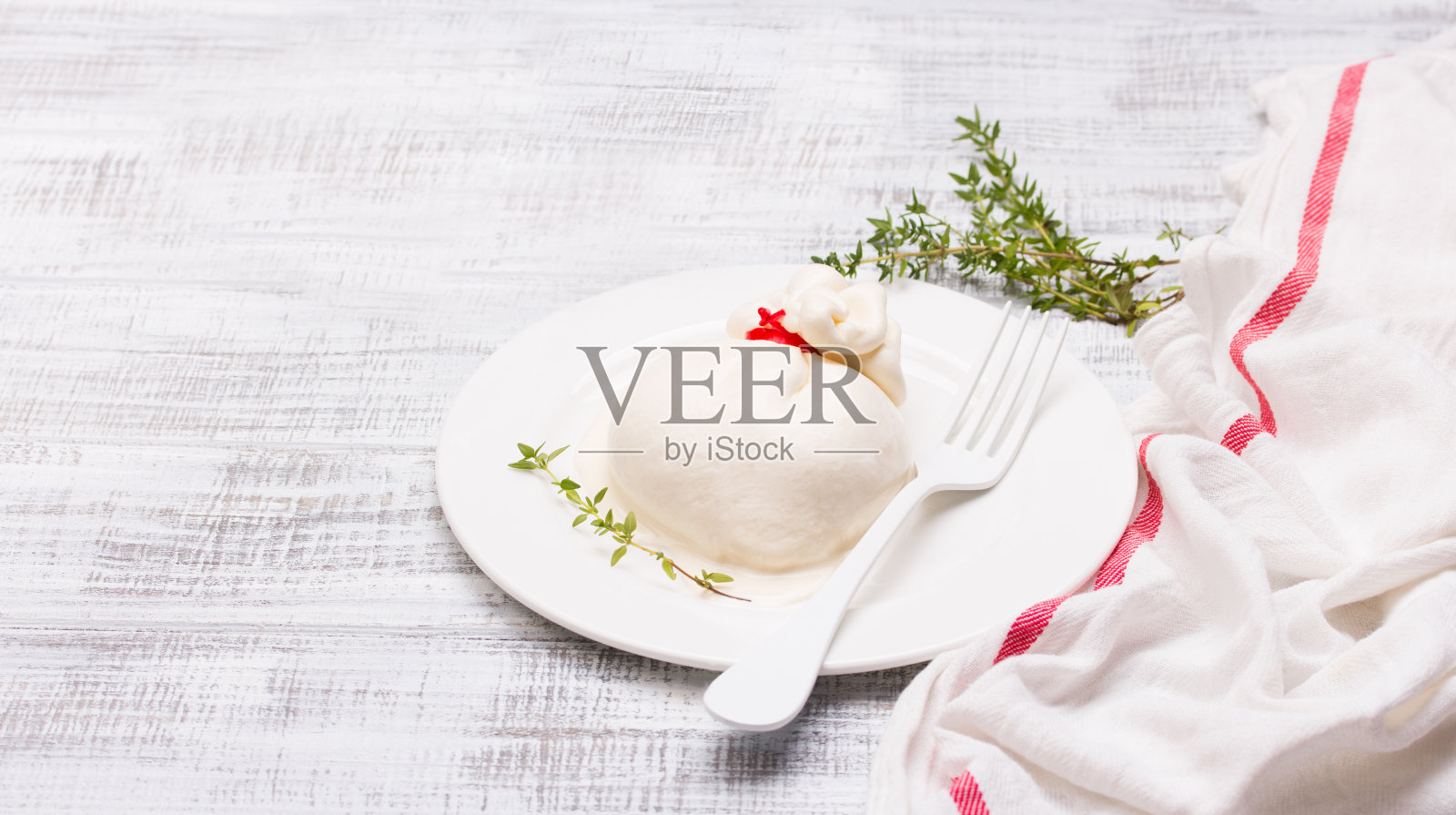 布拉塔奶酪，由马苏里拉奶酪和奶油制成的新鲜意大利奶酪。照片摄影图片