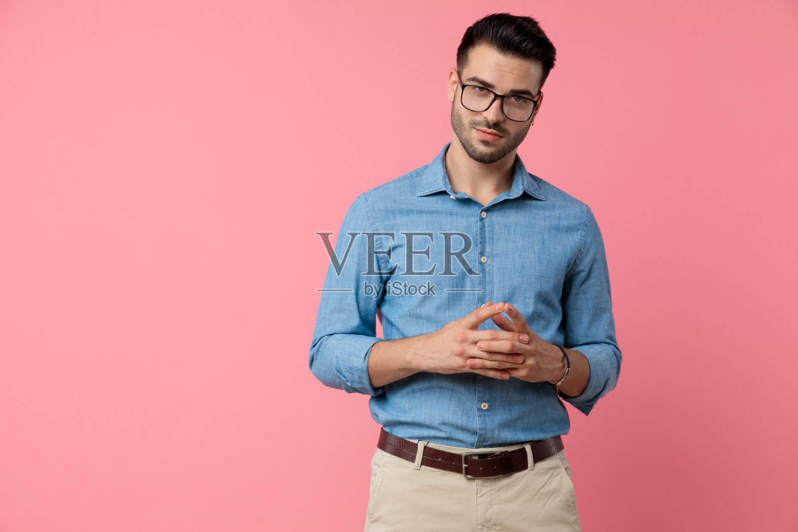 戴眼镜的年轻休闲男人交叉手指照片摄影图片