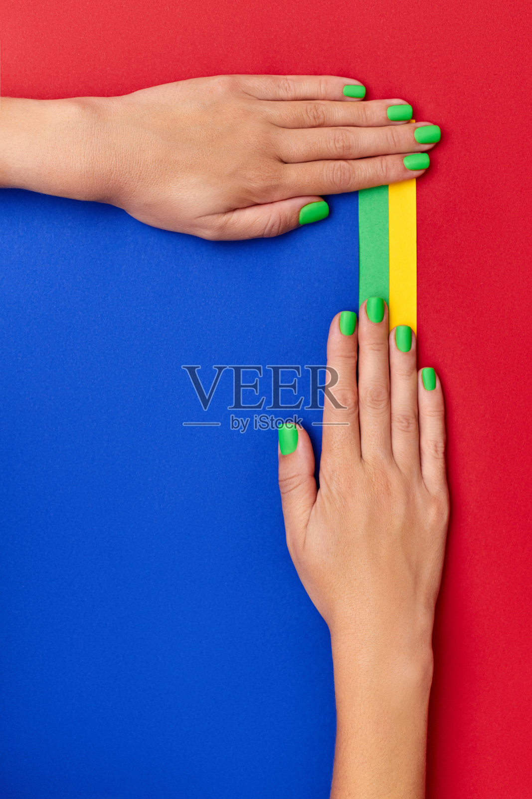 绿色指甲的女性双手在彩色背景上特写照片摄影图片