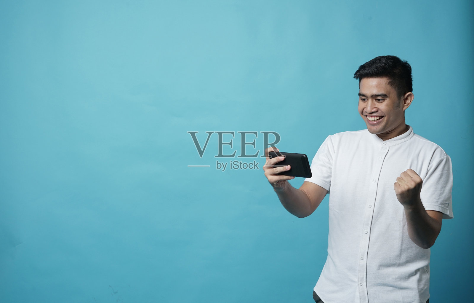 东南亚年轻男子在智能手机上玩游戏照片摄影图片