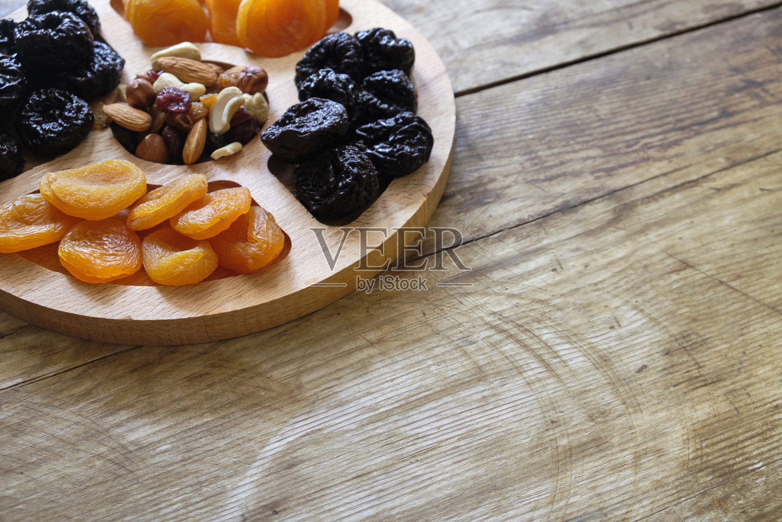 杏干，梅干和坚果混合在风化的木质背景下照片摄影图片