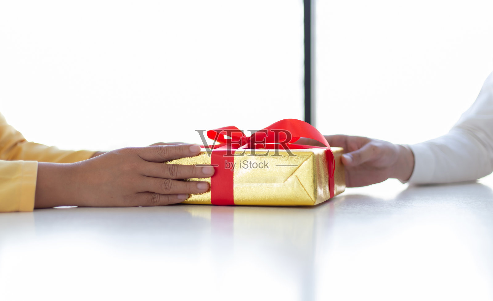 在重要节日（新年、圣诞节）向年轻女性赠送礼盒的年轻人。赠送礼物概念照片摄影图片