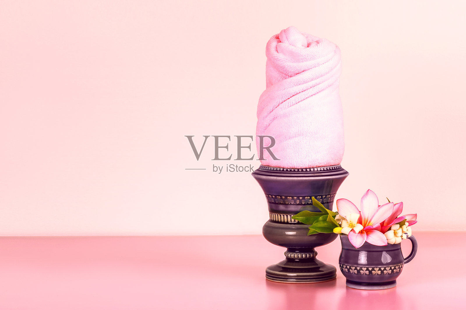带毛巾和鲜花的陶瓷碗套装，粉色背景，留白照片摄影图片