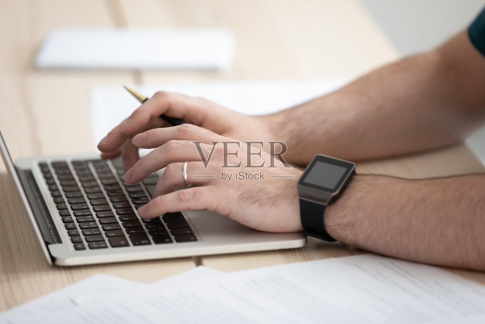 近距离观察在办公室用笔记本电脑打字的年轻商人。照片摄影图片