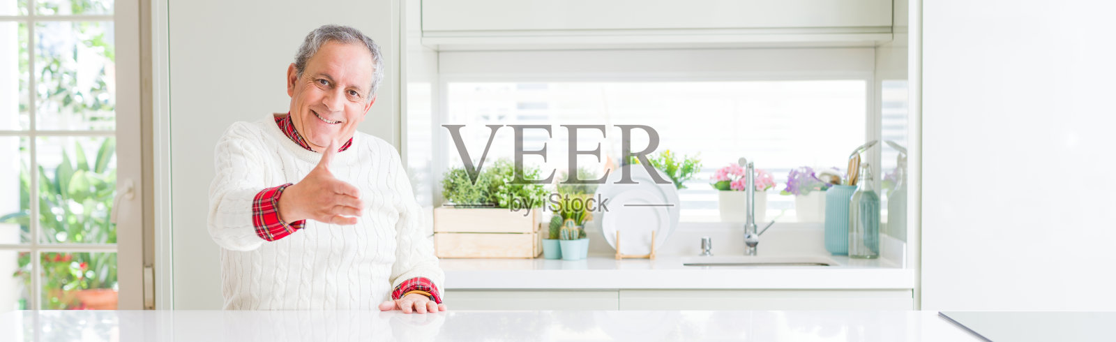 家中友善微笑并握手的年长男子照片摄影图片