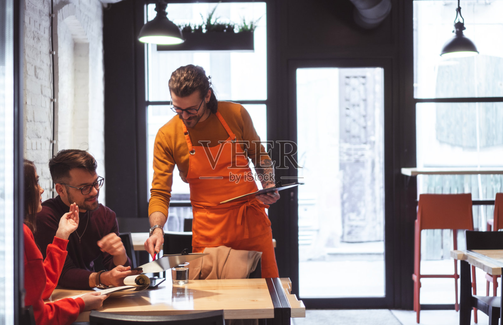 服务员为年轻夫妇点餐照片摄影图片