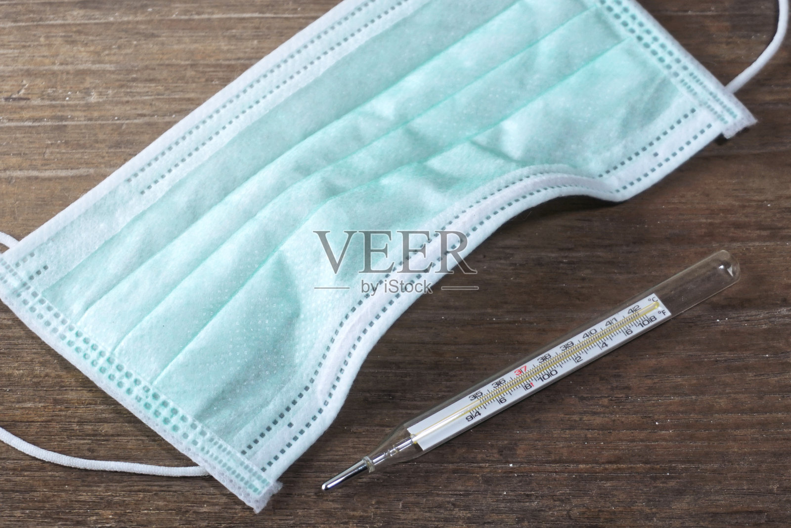 俯视图细菌口罩和温度计在桌子上。照片摄影图片