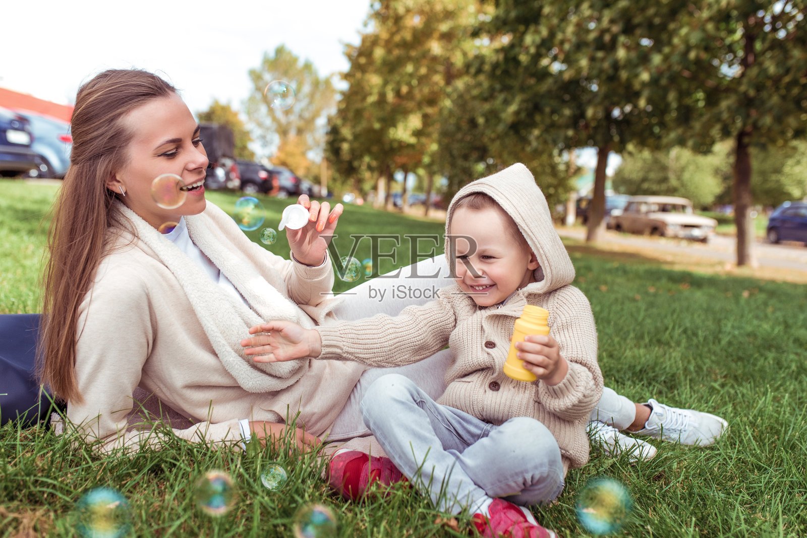 年轻家庭在草坪上吹泡泡，享受亲子时光照片摄影图片