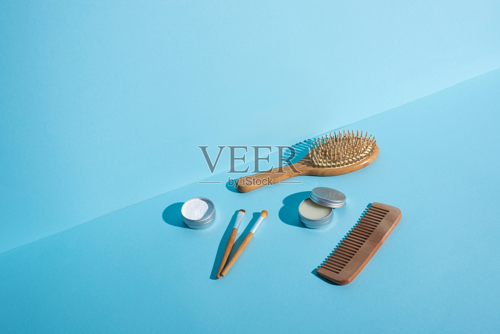 发刷，梳子，罐蜡和牙粉，化妆品刷在蓝色的背景，零浪费的概念照片摄影图片