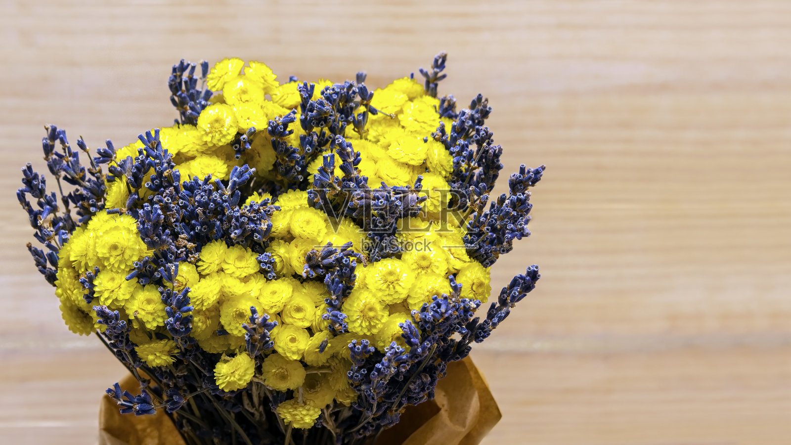 一束干的可爱的黄色和蓝色的花在木制的背景上。照片摄影图片