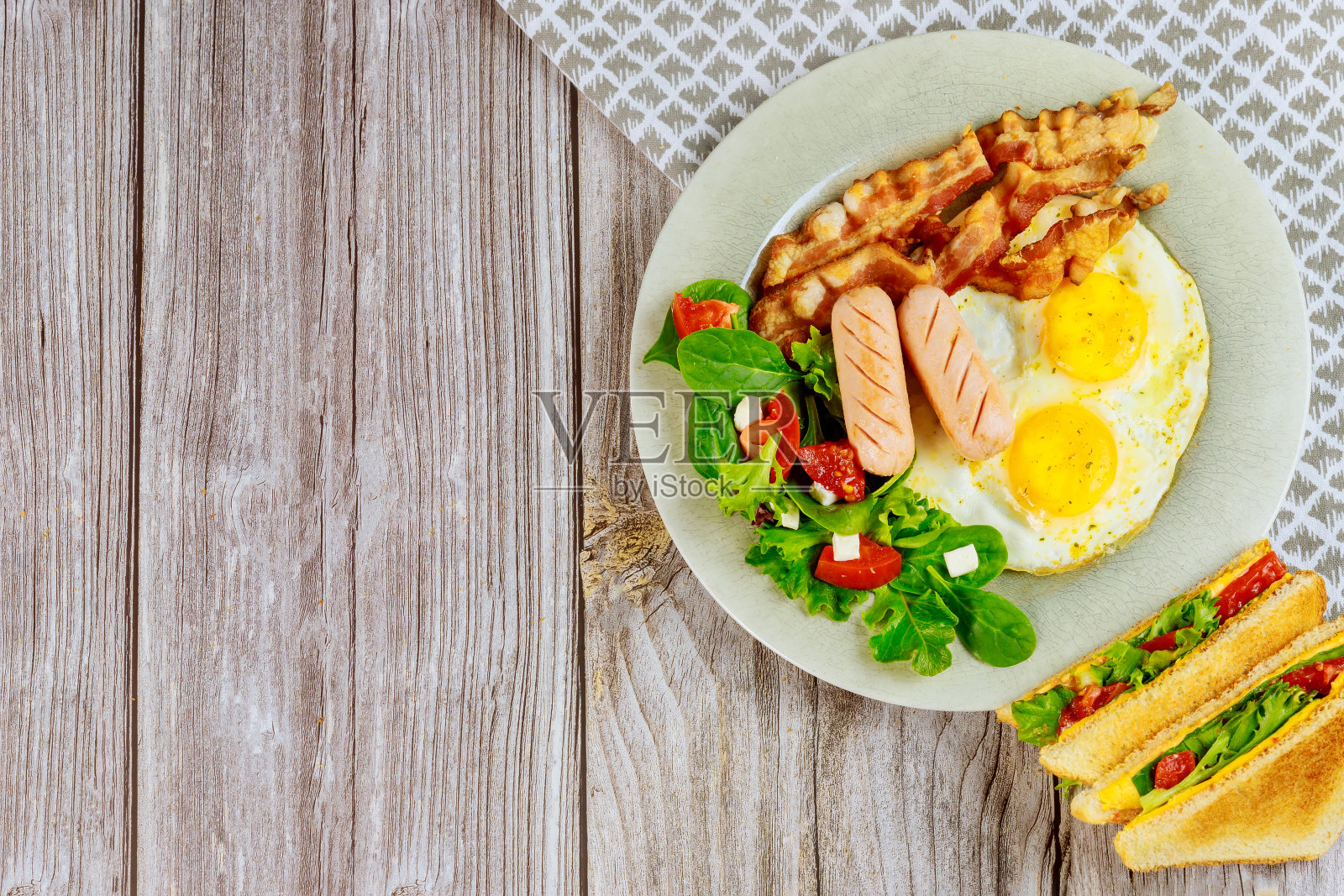 美味的早餐，鸡蛋，培根，沙拉和烤奶酪三明治。照片摄影图片