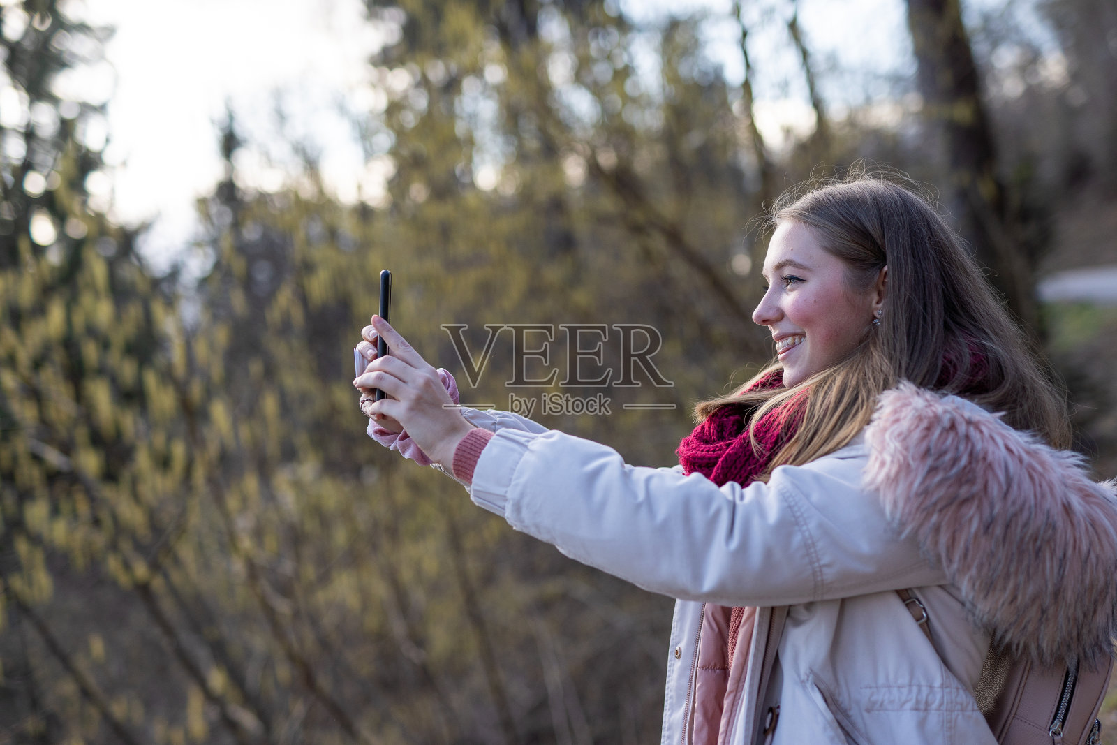 在户外用智能手机自拍的白人女孩照片摄影图片