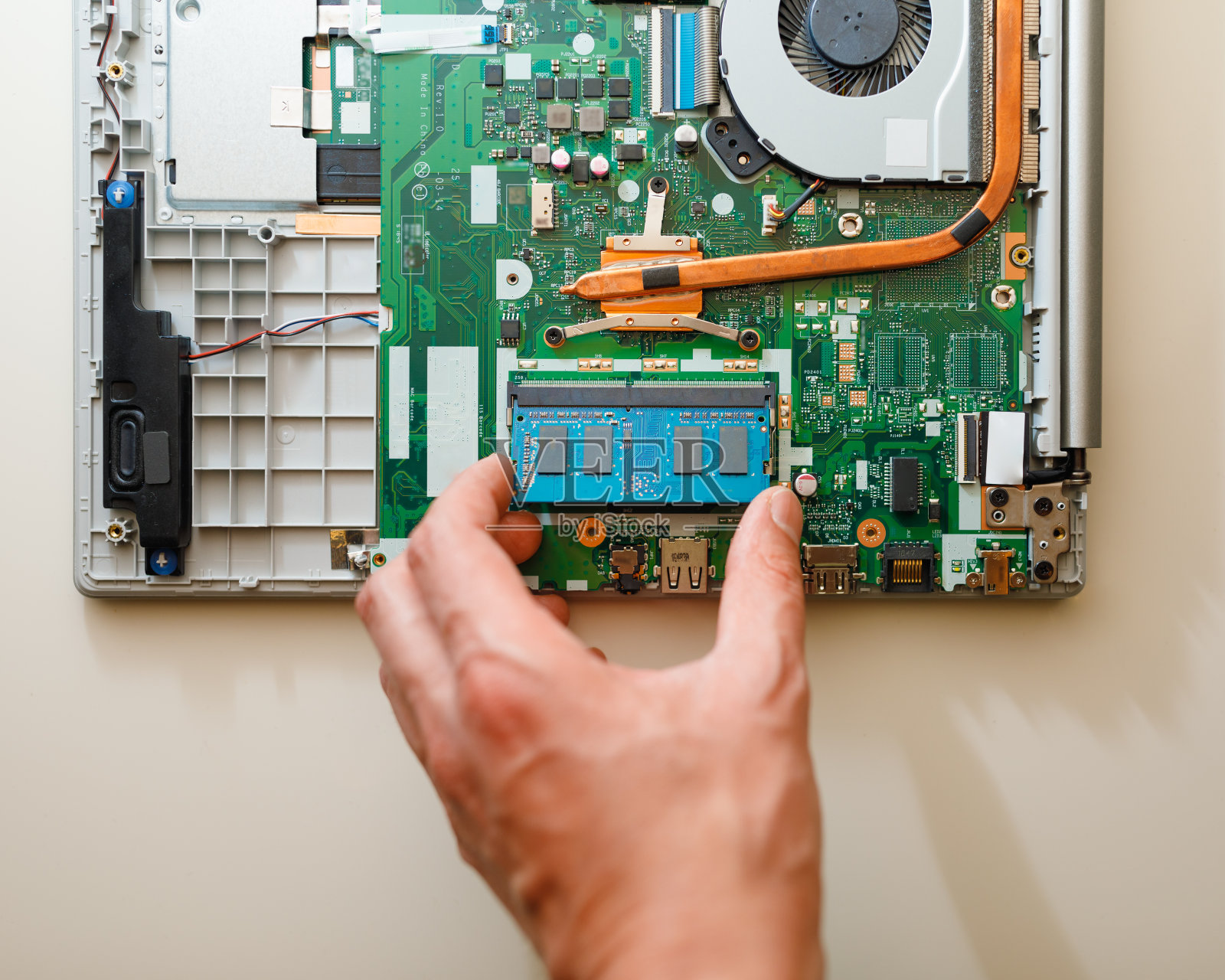 用手在笔记本电脑中安装DDR4内存条照片摄影图片