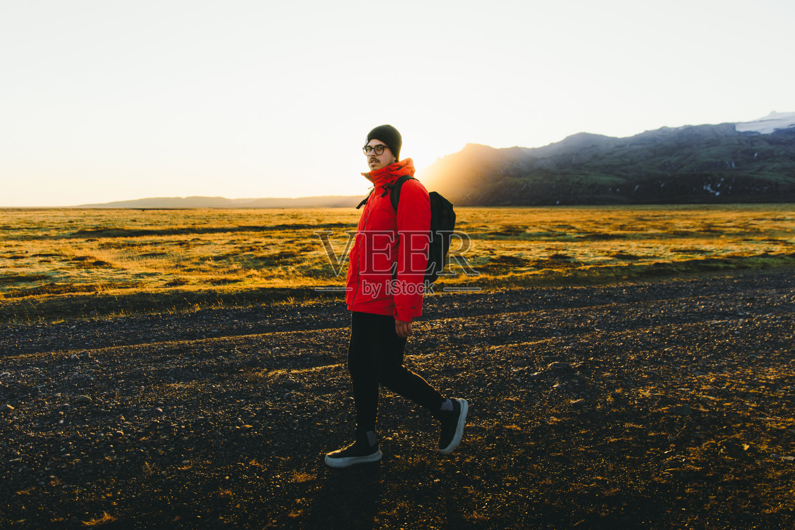 背包客在冰岛徒步旅行时欣赏日落照片摄影图片