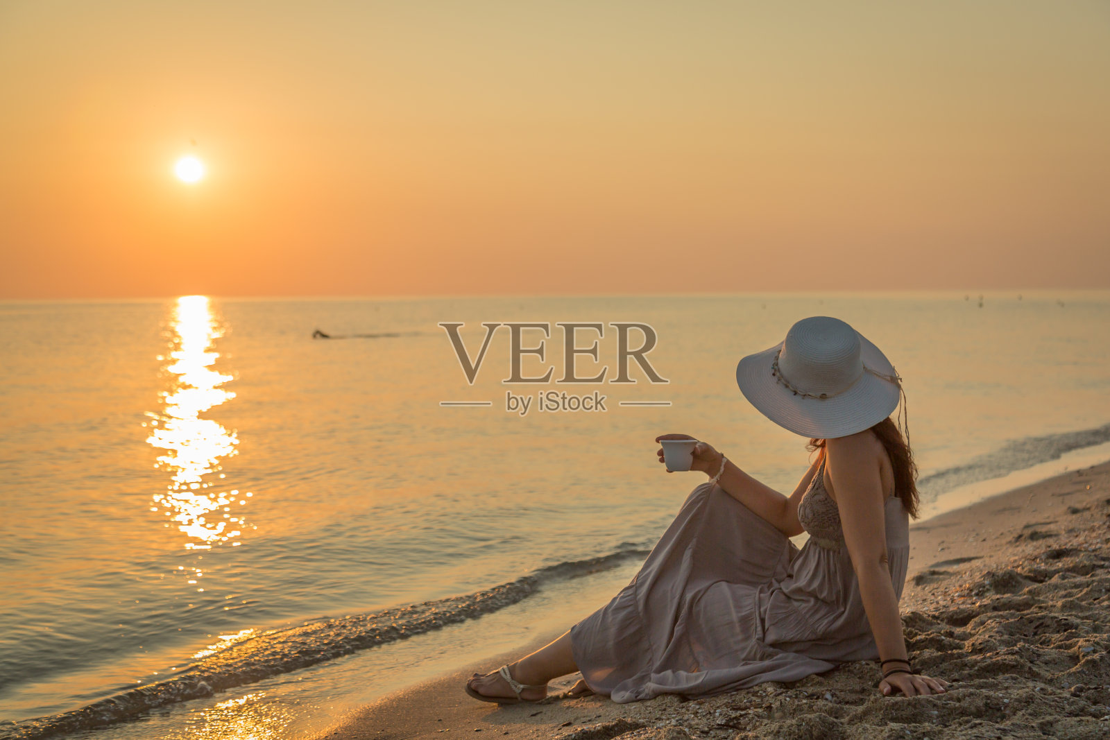 年轻女人在海滩早晨喝咖啡照片摄影图片