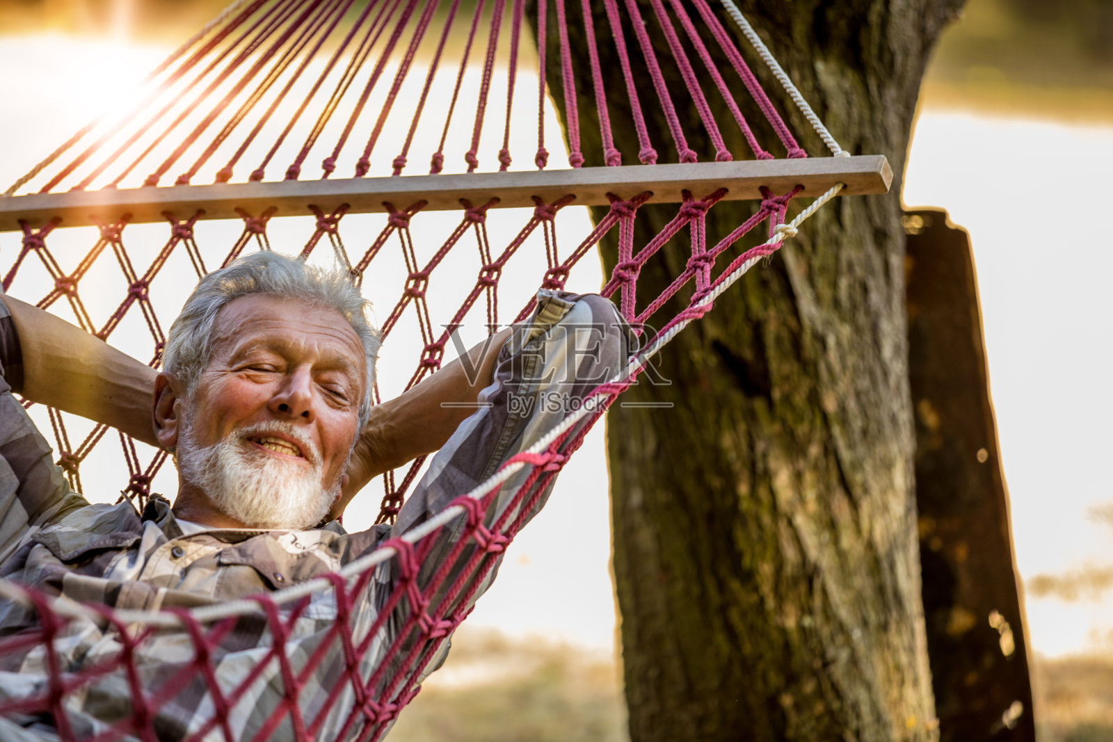老人躺在吊床上照片摄影图片