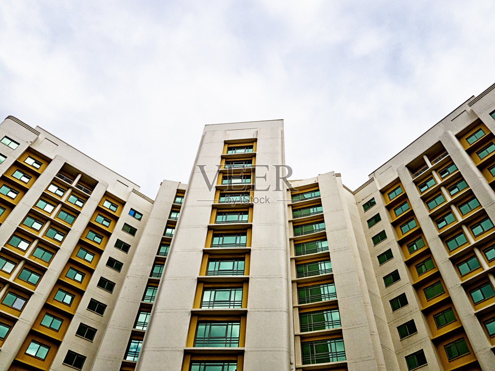 仰望着一座高高的、弯曲的多层建筑照片摄影图片