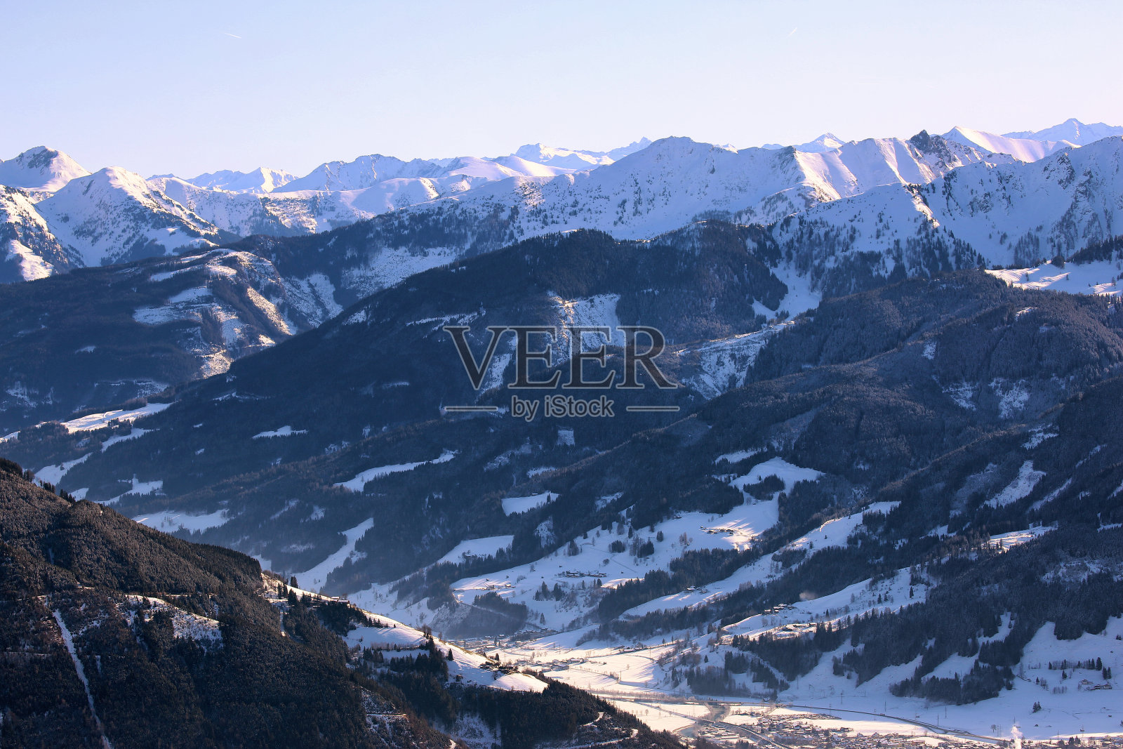 鸟瞰冬季奥地利山谷村庄从阳光明媚的阿尔卑斯山脉的高点照片摄影图片