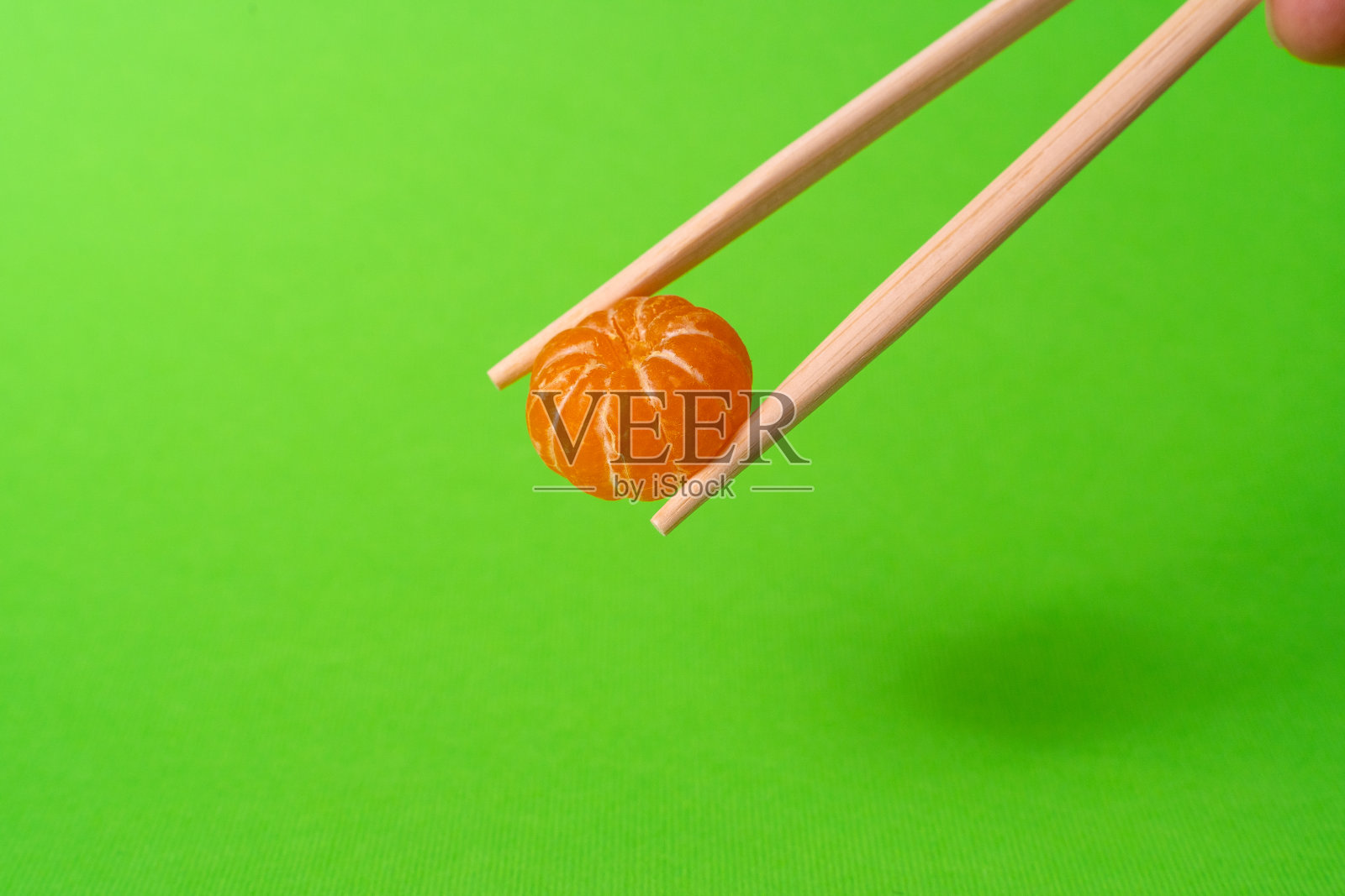 绿色背景的小柑橘筷子照片摄影图片