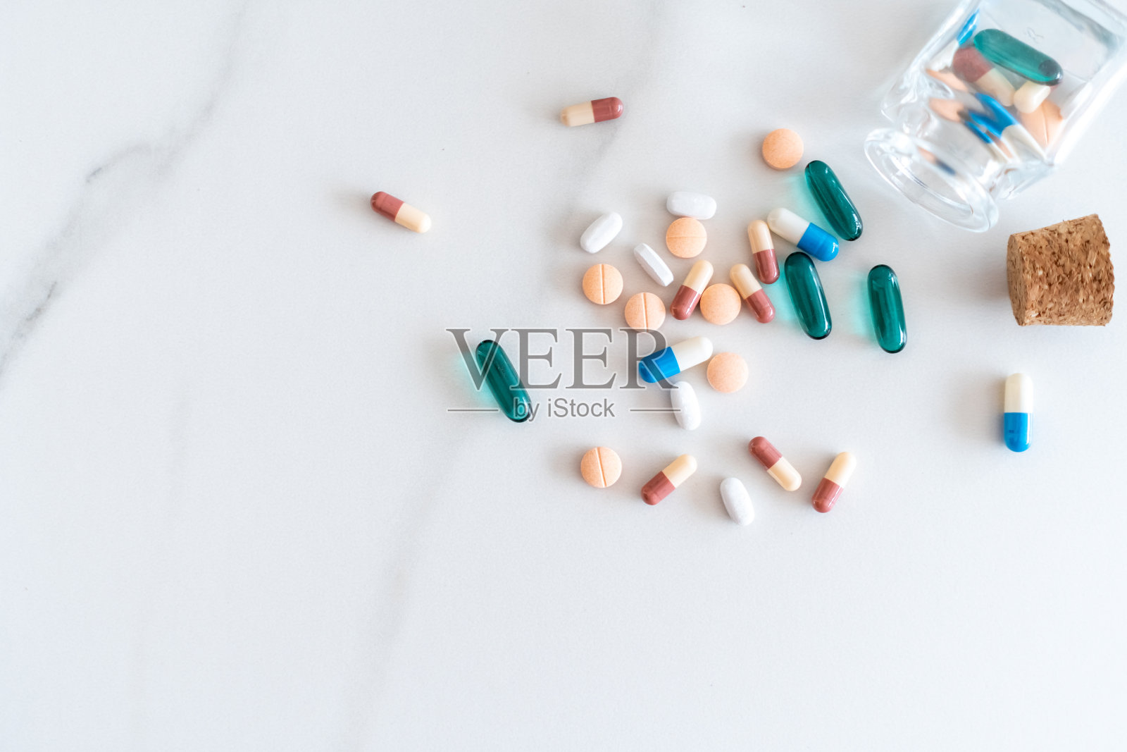 俯视图药片剂从药丸瓶大理石纹理白色的背景。保健医疗生活方式趋势概念。照片摄影图片